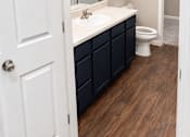 Thumbnail 38 of 46 - A bathroom with a white door and a white sink.