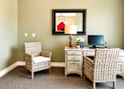 Thumbnail 30 of 46 - A room with a chair, desk, and a mirror.