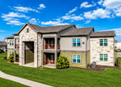Thumbnail 4 of 46 - A large two-story house with a stone facade and a garage.