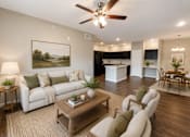 Thumbnail 44 of 46 - A living room with a white couch, a coffee table, and a painting on the wall.