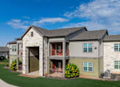 Thumbnail 2 of 23 - A large house with a grey roof and a garage door.