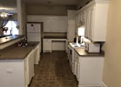 Thumbnail 6 of 7 - a large kitchen with white cabinets and appliances and counters