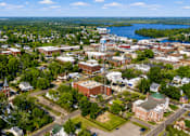 Thumbnail 2 of 11 - A small town with a waterfront and a church with a steeple.