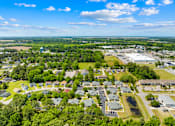 Thumbnail 4 of 11 - A bird's eye view of a residential area with houses and a parking lot.