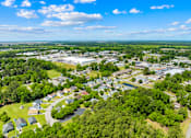 Thumbnail 5 of 11 - A bird's eye view of a residential area with houses, trees, and a parking lot.