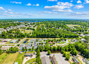 Thumbnail 8 of 11 - A bird's eye view of a residential area with houses, trees, and a body of water.