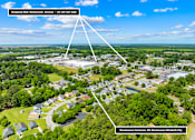 Thumbnail 9 of 11 - An aerial view of a residential area with a shopping mall and grocery store nearby.