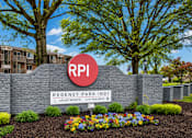 Thumbnail 9 of 17 - A sign for Regency Park Apartments is in front of a building and trees.