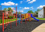 Thumbnail 4 of 17 - A playground with a blue slide and red monkey bars.
