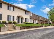Thumbnail 7 of 17 - A row of townhouses with a clear blue sky above.