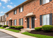 Thumbnail 8 of 17 - A row of red brick houses with black shutters and white windows.