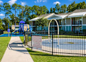 Thumbnail 12 of 14 - A playground with a blue slide and a sign on a fence.
