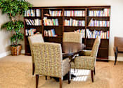 Thumbnail 5 of 9 - A room with a large bookshelf filled with books and a table with chairs.