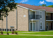 Thumbnail 2 of 4 - A brick building with a balcony and a sign on the wall.