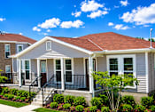 Thumbnail 1 of 4 - A house with a red roof and a white front porch.