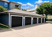 Thumbnail 3 of 23 - A row of black garage doors in front of a blue house.