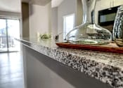 Thumbnail 22 of 26 - a kitchen counter top with a glass vase on it