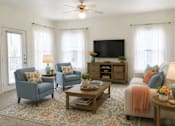 Thumbnail 2 of 5 - A living room with a television, two chairs, a sofa, and a coffee table.