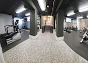 Thumbnail 36 of 43 - A gym with a variety of exercise equipment including treadmills, stationary bikes, and weights.