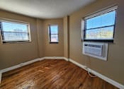Thumbnail 32 of 43 - A room with wooden floors and two windows.