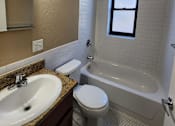 Thumbnail 13 of 43 - A bathroom with a sink, toilet, and bathtub.