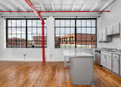 Thumbnail 9 of 9 - A kitchen with a large island and a red pipe running along the ceiling.