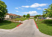 Thumbnail 4 of 12 - A residential street with houses on both sides and a red curb.