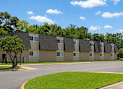 Thumbnail 3 of 5 - Apartment complex with a tree in front of it.