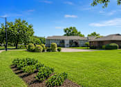 Thumbnail 5 of 6 - A grassy field with a building in the background.