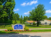 Thumbnail 6 of 6 - A sign for St. Luke Apartments is in front of a green lawn.