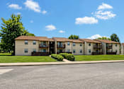 Thumbnail 2 of 4 - Apartment complex with a clear blue sky above.