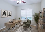 Thumbnail 14 of 23 - A room with a desk, chair, and a fan.