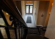 Thumbnail 42 of 43 - A hallway with a staircase leading to the second floor.