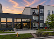 Thumbnail 4 of 8 - A modern apartment complex with a fire hydrant in front.