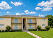 Thumbnail 10 of 10 - A large two-story apartment building with a lawn in front.