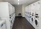 Thumbnail 2 of 5 - a room full of washers and dryers in a laundry room