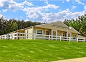Thumbnail 5 of 5 - a yellow house with a white fence and green grass