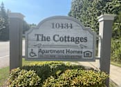 Thumbnail 1 of 5 - a sign for the cottages apartments and apartment homes