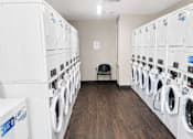 Thumbnail 5 of 5 - A laundromat with rows of washers and dryers.