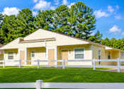 Thumbnail 1 of 5 - A yellow house with a white fence in front of it.
