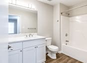Thumbnail 37 of 43 - A white bathroom with a toilet, sink, and bathtub.