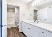 Thumbnail 38 of 43 - A white bathroom with a toilet, sink, and mirror.