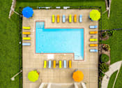 Thumbnail 42 of 43 - A large blue swimming pool surrounded by yellow and blue sun loungers.