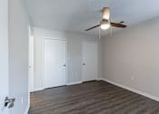 Thumbnail 16 of 35 - A room with a ceiling fan and three doors.