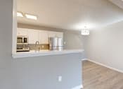 Thumbnail 23 of 35 - A kitchen with white cabinets and a wooden floor.