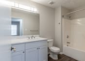 Thumbnail 19 of 35 - A white bathroom with a toilet, sink, and bathtub.