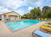 Thumbnail 6 of 35 - A pool area with a house and chairs.