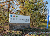 Thumbnail 4 of 35 - A sign that says "The Grand at 150" is in front of a tree.