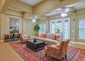 Thumbnail 4 of 23 - A living room with a rug, a couch, a coffee table, and a dining table.