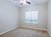 Thumbnail 22 of 23 - A room with a ceiling fan and a window with blinds.